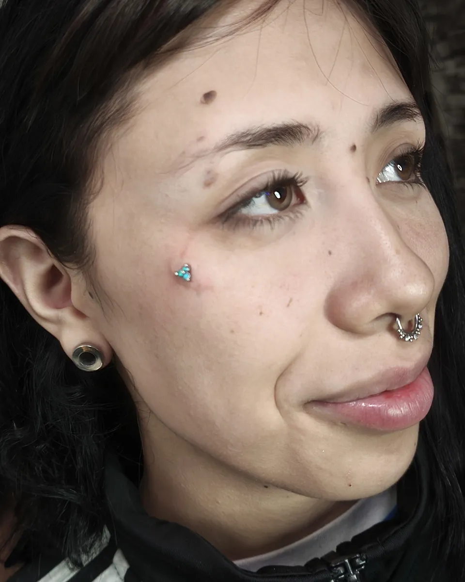 Microdermal en el pómulo, con septum y expansión pequeña en el lóbulo
